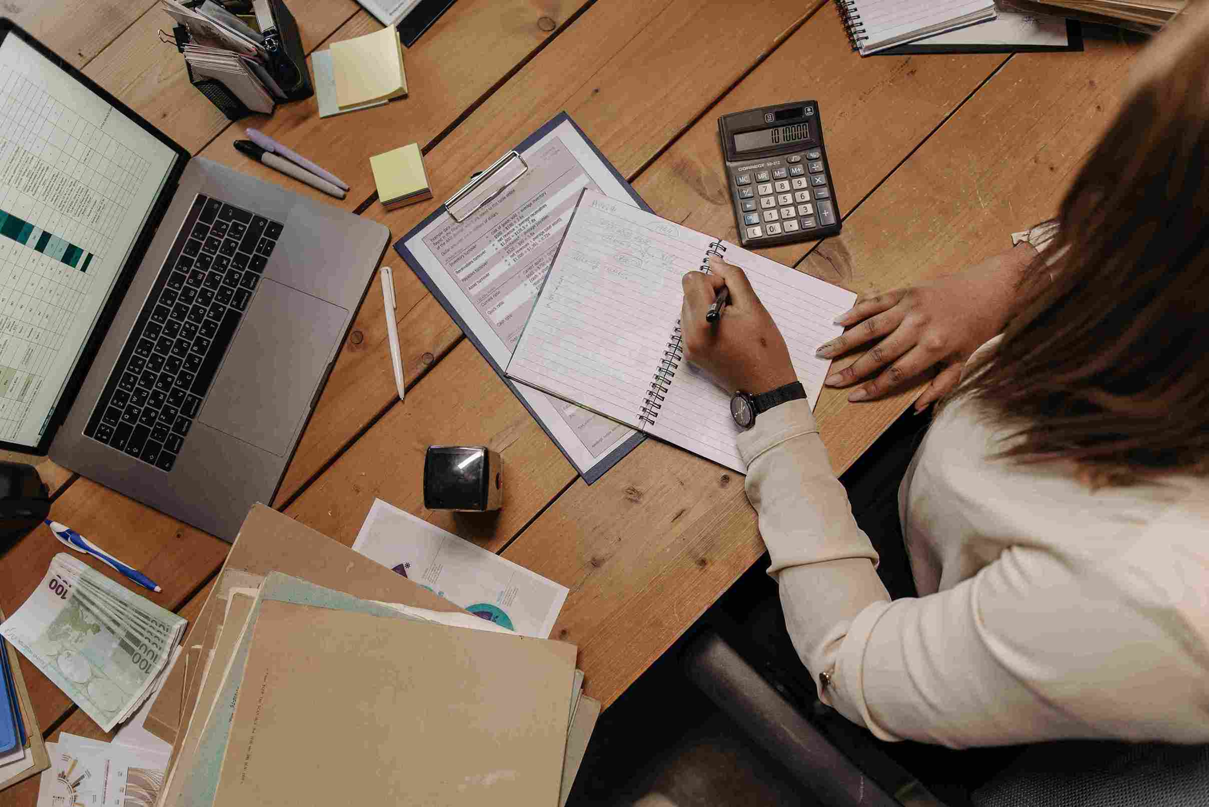 Accountant reviewing documents and notes at desk to identify workflow bottlenecks and readiness for accounting workflow automation